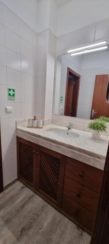 a bathroom with a sink and a large mirror at Marear in Porto Santo