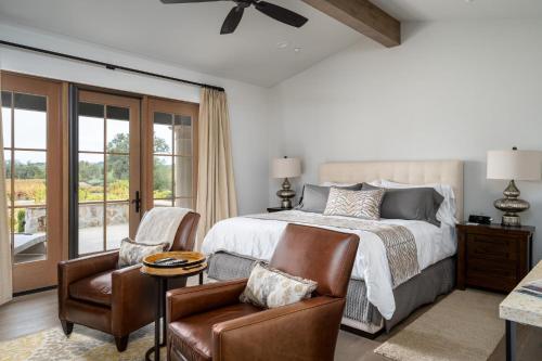 a bedroom with a bed and two chairs at Grand Reserve Inn in Plymouth