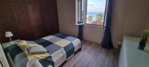a small bedroom with a bed and a window at Marear in Porto Santo