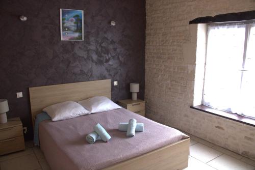 a bedroom with a bed with two pillows and a window at Gites la Marquise in Prisse-la-Charriere