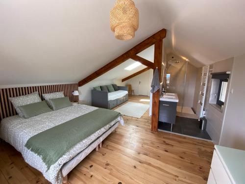 a bedroom with a large bed and a bathroom at Gîte au cœur des Gorges de la Loire in Aurec-sur-Loire