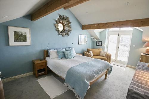 1 dormitorio con 1 cama grande y 1 silla en The Blue House Bed and Breakfast, en High Newton