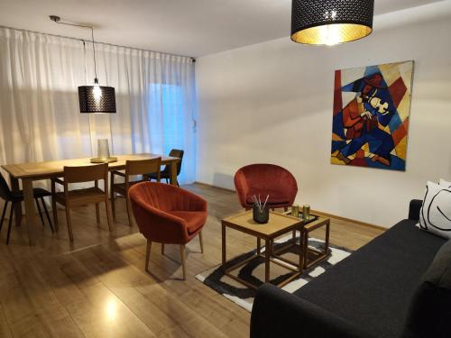 sala de estar con sofá, mesa y sillas en A9 Apartment, en Ingolstadt