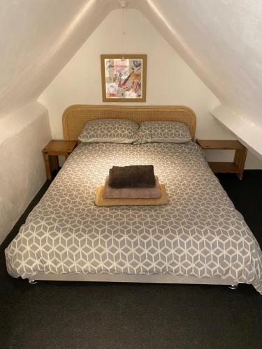 a bedroom with a bed with a black pillow at The Dairy-Petting Farm-Indoor Pool-Play Areas-Parkland-Woodland-Lake,Ponds&Stream-min2 night stay in Lechlade