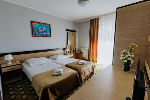 a hotel room with a bed with two towels on it at Panorama_SPA in Trzęsacz