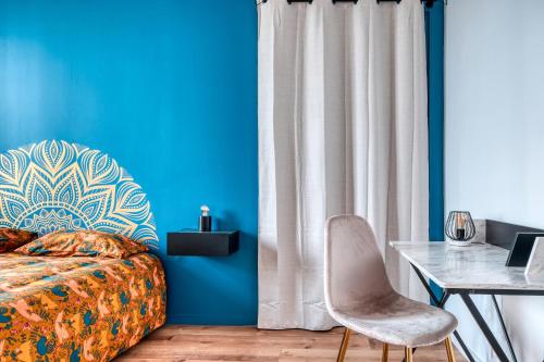 a bedroom with blue walls and a bed and a desk at Superbe 2 pièces avec Jacuzzi privatif face Gare Proche Cathédrale in Chartres