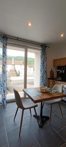 une table et une chaise dans une cuisine avec une fenêtre dans l'établissement L'Escapade Cévenole, à Le Collet-de-Dèze
