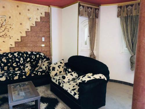 a living room with a couch and a chair at شقة مفروشة in Mansoura