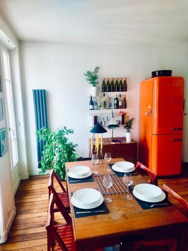 - une table à manger avec des chaises et un réfrigérateur rouge dans l'établissement Bel appartement à Paris, à Paris