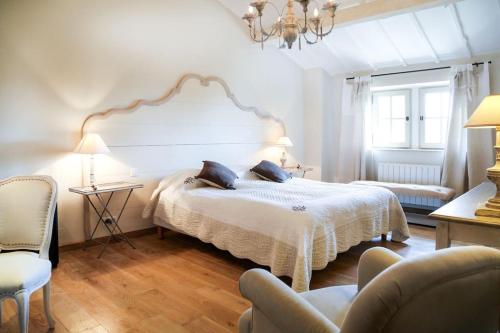 een slaapkamer met een groot bed met een witte sprei bij La Gardette, Gordes, vue panoramique Ventoux in Gordes