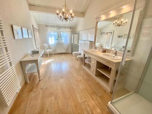 uma grande casa de banho com um lavatório e um espelho em La Gardette, Gordes, vue panoramique Ventoux em Gordes