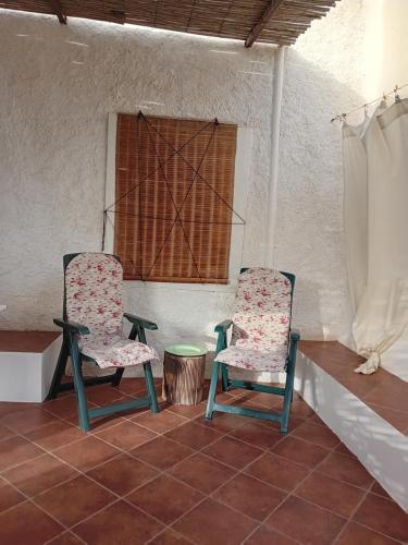 two chairs in a room with a table and a window at Belvedere in Pantelleria