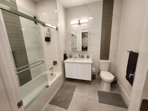 La salle de bains est pourvue de toilettes, d'un lavabo et d'une douche. dans l'établissement Close to NYC, 10 Guest, Luxurious 3Bedroom Apartment, à Union City