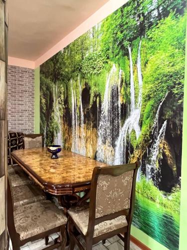a dining room with a waterfall mural on the wall at HamEl Guest House in Odzun