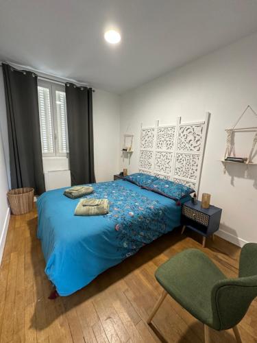 a bedroom with a blue bed and a chair at Bienvenu à l’appart bien-être in Souvigny