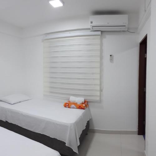 een witte kamer met een bed en een raam bij Apartamentos sophia in San Andrés
