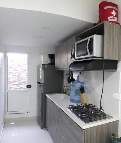 a kitchen with a microwave and a stove at Apartamentos sophia in San Andrés