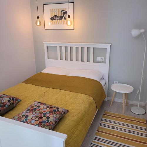 a small bedroom with a bed and a table at Apartamenty Batorego 4 in Bydgoszcz