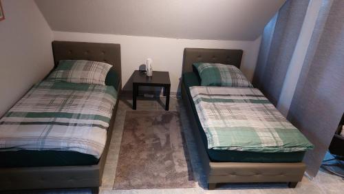 2 camas en una habitación con mesa auxiliar en Ferienwohnung Bell im Brohltal, en Niederdürenbach
