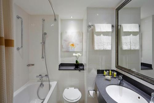 La salle de bains est pourvue d'un lavabo, d'une baignoire et de toilettes. dans l'établissement London Marriott Hotel Marble Arch, à Londres