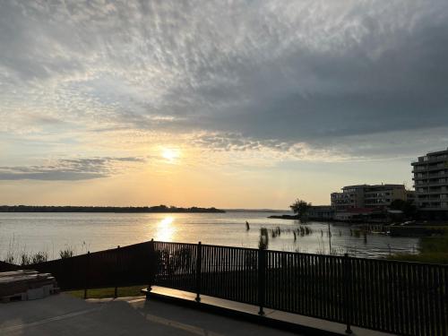 a view of a body of water with the sun setting at Blue Luxury Apartment Lake On in Mamaia