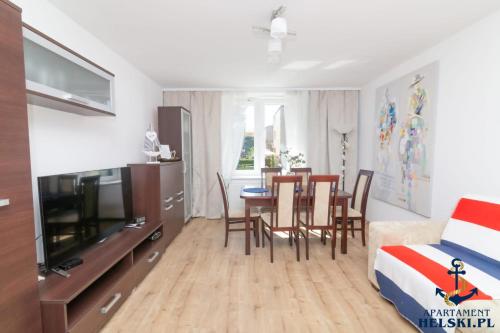 a living room with a bed and a dining room table at Apartament Helski in Hel