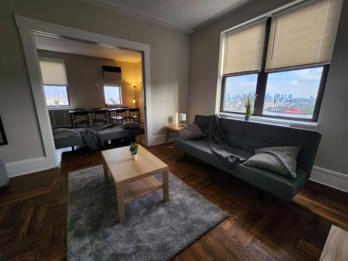 ein Wohnzimmer mit einem Sofa und einem Tisch in der Unterkunft Elegant 2 bed gem! mins from NYC in Union City