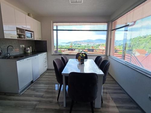 une cuisine avec une table et des chaises ainsi qu'une grande fenêtre dans l'établissement Anabela Apartment, à Ohrid