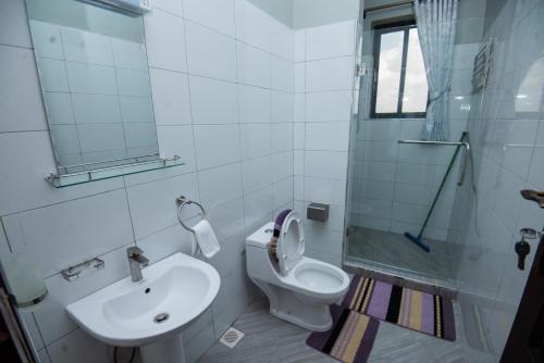 a bathroom with a toilet and a sink and a shower at Lubowa View Apartments in Kampala