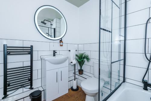a bathroom with a toilet and a mirror at Newly Refurbished 3 Double Bedroom Knowsley Liverpool Townhouse in Knowsley