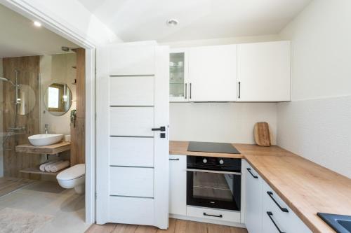 a kitchen with white cabinets and a sink at Domek pod Magurką in Międzybrodzie Bialskie