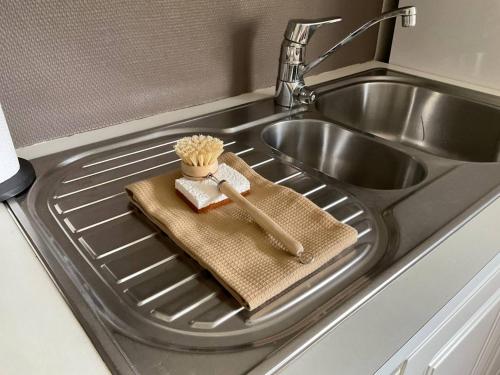 a kitchen sink with a wooden brush and a utensil at Leknes City Apartment in Leknes
