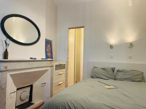 Schlafzimmer mit einem Bett und einem Wandspiegel in der Unterkunft Joli T2 avec balcon au Cours Julien in Marseille