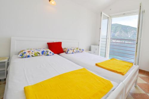 una camera da letto con un grande letto con lenzuola gialle e una finestra di Apartment's Belvedere a Kotor (Cattaro)