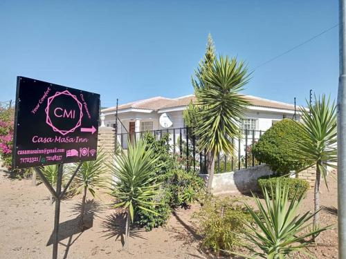 a sign in front of a house with palm trees at Casa MaSa Inn in Francistown