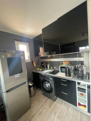 une cuisine avec un réfrigérateur et une machine à laver dans l'établissement tout pour VOTRE confort, au Lavandou