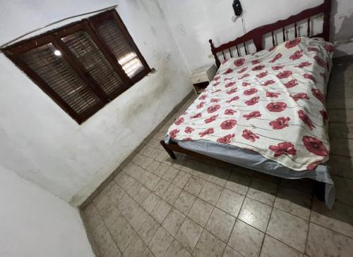 Un dormitorio con una cama con flores rojas. en La roka gym casa, en San Salvador de Jujuy