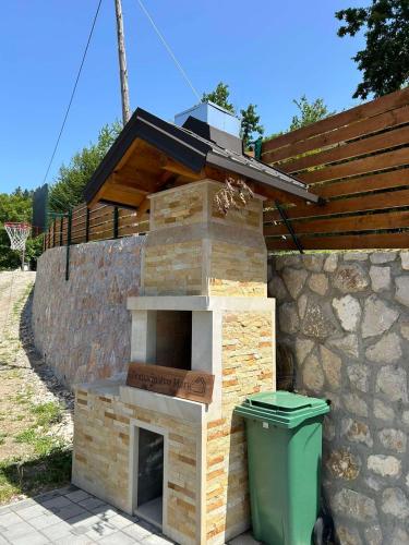 a outdoor brick oven with a green trash can at Domaćinstvo Marić in Ivanjica