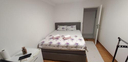 a small bedroom with a bed with two books on it at Apartman Kristina in Trebinje