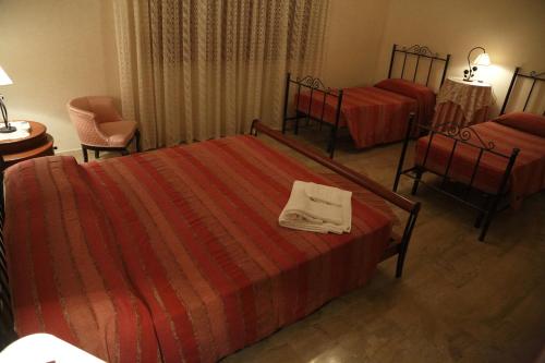 a hotel room with two beds and a table and chairs at Trapani Bedrooms in Trapani