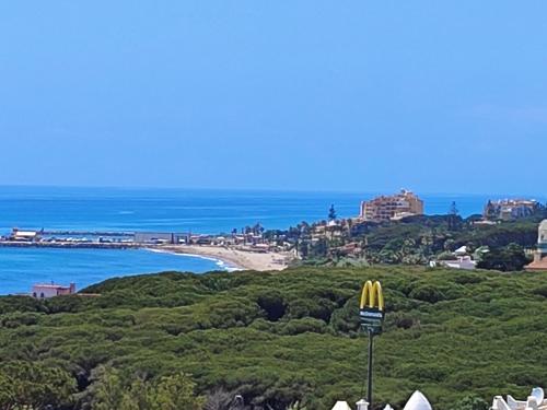 una vista de una playa con un cartel de mcdonalds en PRECIOSO APTO 1 LINEA PLAYA VISTAS AL MAR, en Sitio de Calahonda