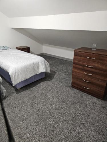 a bedroom with a bed and a wooden dresser at One bedroom flat in Birmingham