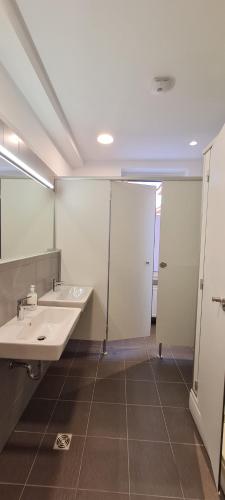 Baño con 2 lavabos y espejo en Zagreb budget rooms, en Zagreb