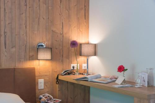 a bedroom with a desk with two lamps on it at Hotel La Romantica in Le Prese, Poschiavo