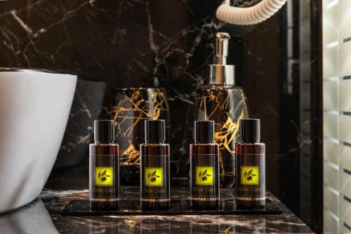 un gruppo di quattro bottiglie di oli essenziali su un contatore di Hotel Dionysis Studios ad Adámas