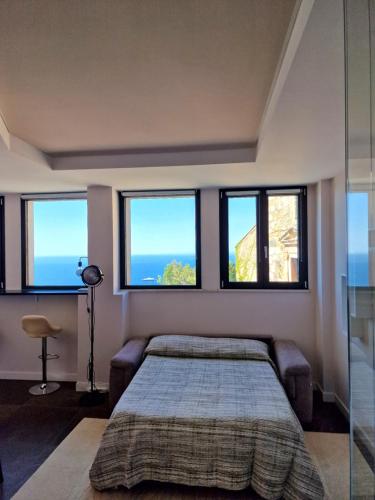a bedroom with a bed and three windows at The White Domus in Taormina