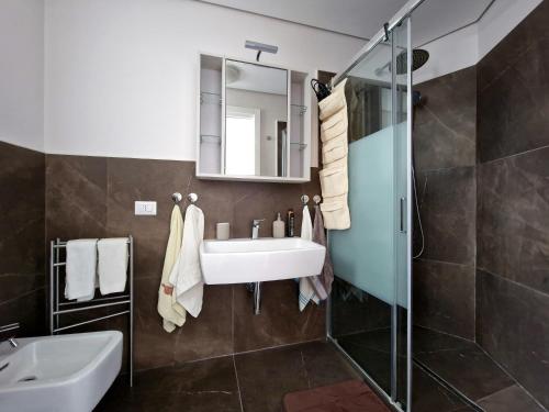 bagno con lavandino e doccia in vetro di The White Domus a Taormina