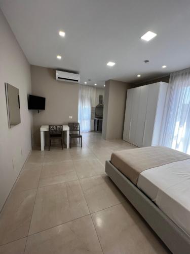 a large bedroom with a bed and a dining room at B&B VIRGILIO LAMEZIA AIRPORT in SantʼEufemia Lamezia