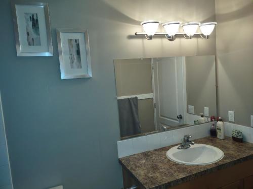 y baño con lavabo y espejo. en Spacious One Bedroom Walkout Basement Suite, en Calgary