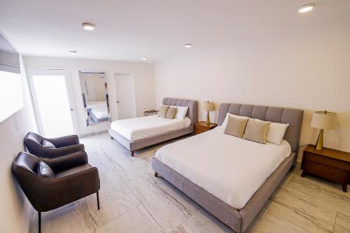 ein Hotelzimmer mit zwei Betten und einem Stuhl in der Unterkunft King Royal Villa - Luxury in Cozumel Center in Cozumel